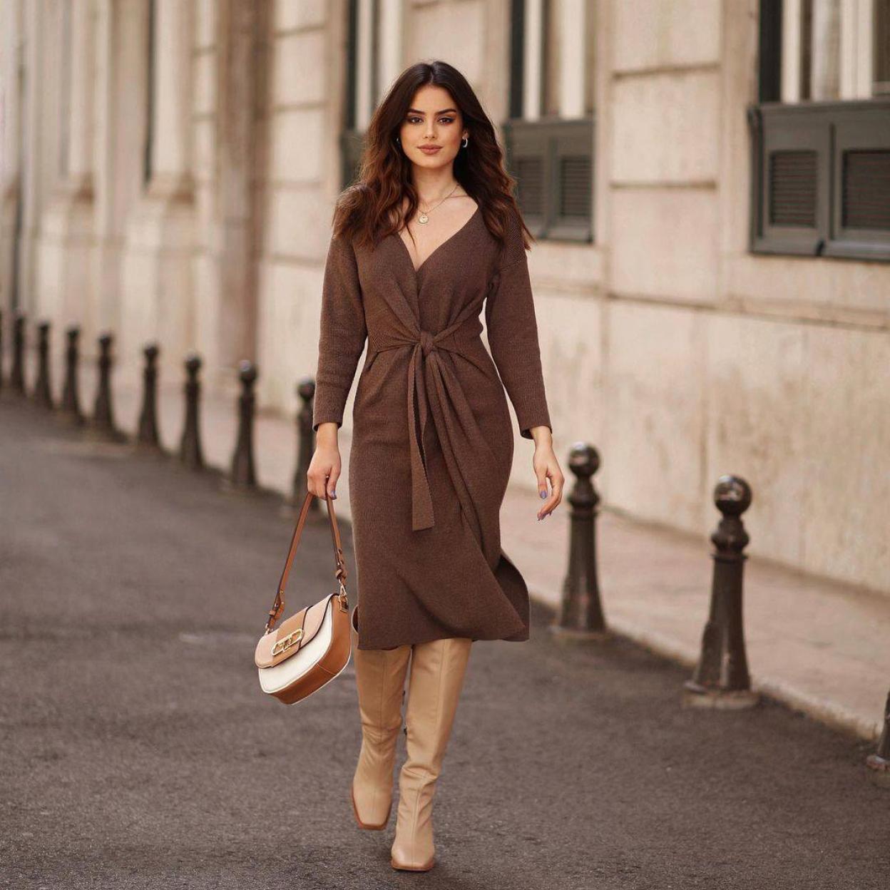La influencer lleva un look con vestido midi y botas altas