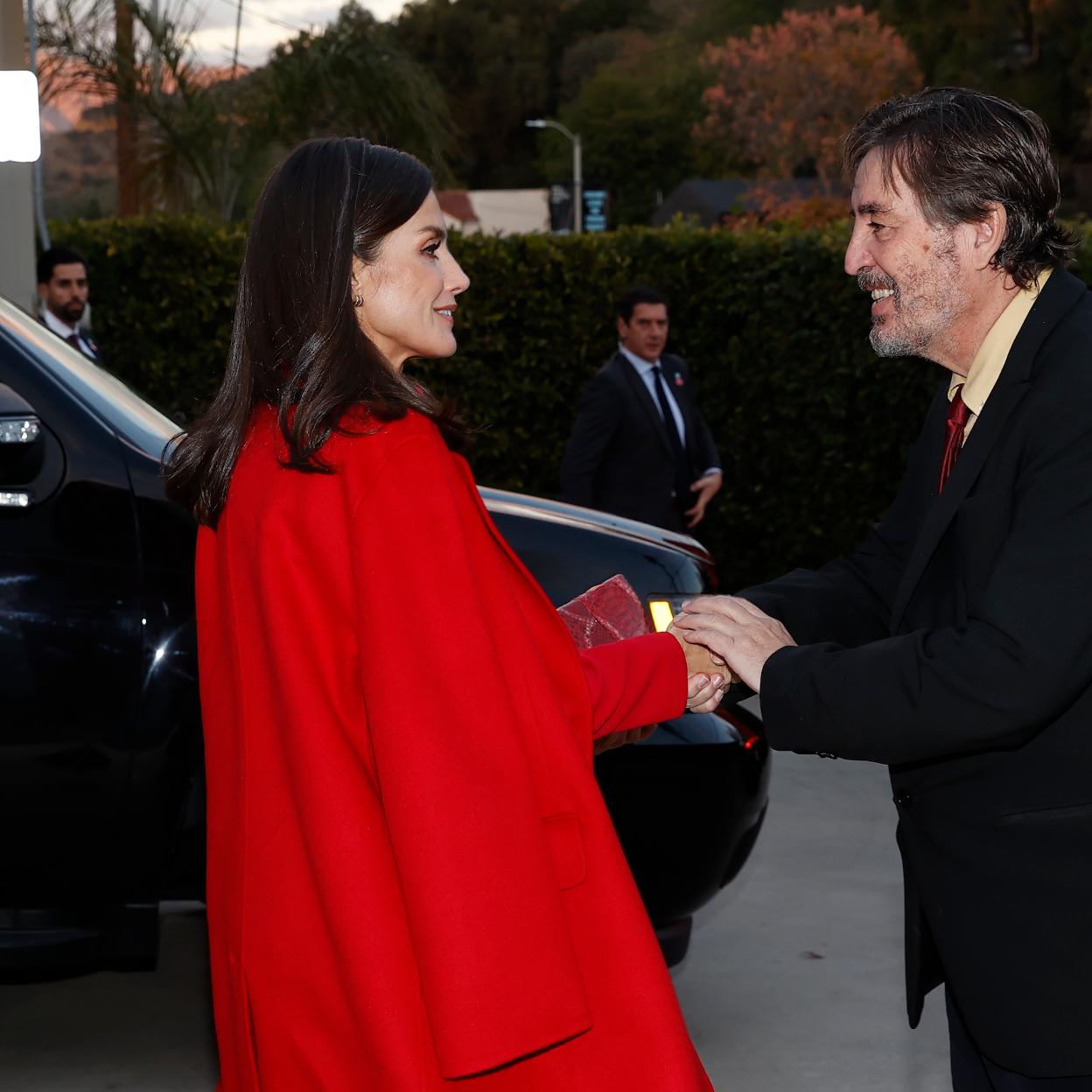 La reina Letizia llegó al nuevo centro del Instituto Cervantes en Los Ángeles con un maravilloso abrigo rojo de Carolina Herrera. En la foto, le estrecha la mano a Luis García Montero, director del Cervantes. 