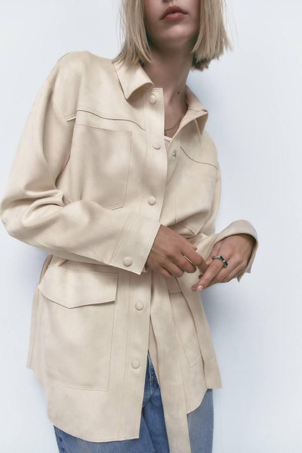 Sobrecamisa larga en tejido efecto ante con cuello solapa, manga larga, bolsillos y cinturón de lazada a juego, en crudo. Cuesta 29,95 euros.