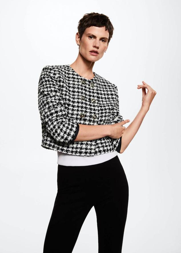 Chaqueta en tejido de tweed con diseño cuadrado, cierre cruzado mediante doble botonadura, manga larga, cuello redondo y estampado de pata de gallo bicolor, en blanco y negro, de Mango. Tiene un coste de 59,99 euros.