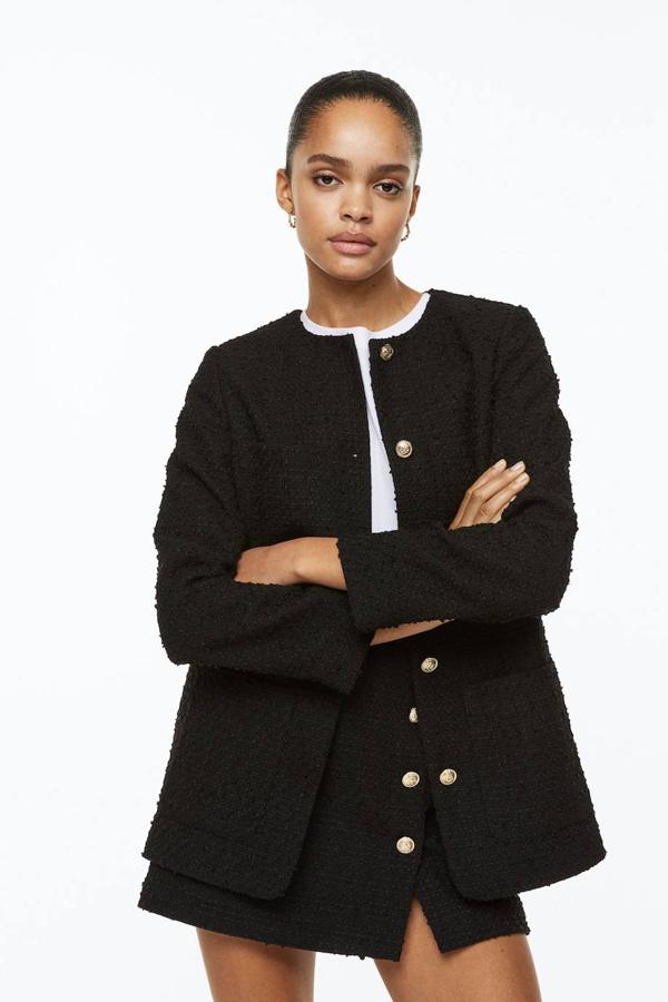Chaqueta en tejido de tweed texturizado con corte estructurado, cuello redondo, manga larga, bolsillos de plastrón y botones con relieve, color negro, de H&M. Hazte con ella por 39,99 euros.