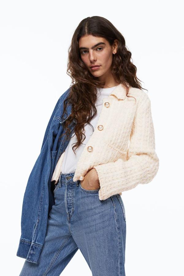 Chaqueta en tejido de punto estructura con diseño cuadrado, cuello solapa, manga larga, bolsillos y botones perla, en blanco natural, de H&M. Su precio es de 49,99 euros.