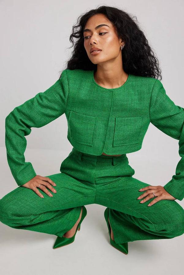 Chaqueta cropped en tejido de tweed con cuello redondo, manga larga y bolsillos de plastrón, en verde, de NA-KD. Puedes comprarla por 51,95 euros.