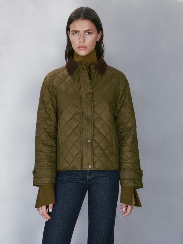 Chaqueta corta acolchada en color verde con cuello de pana en marrón. Precio: 79,95 euros.