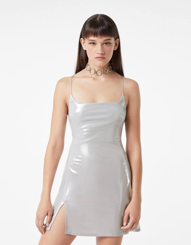 Vestido corto en tejido efecto metalizado con tirantes finos, escote redondo y abertura en el bajo, en plata, de Bershka.