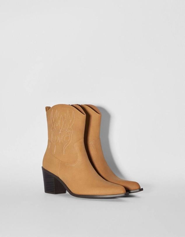 Botas cowboy en tejido efecto piel con bordados de adorno, tirador, terminación en punta y tacón ancho, en marrón claro, de Bershka. Su coste rebajado es de 29,99 euros.