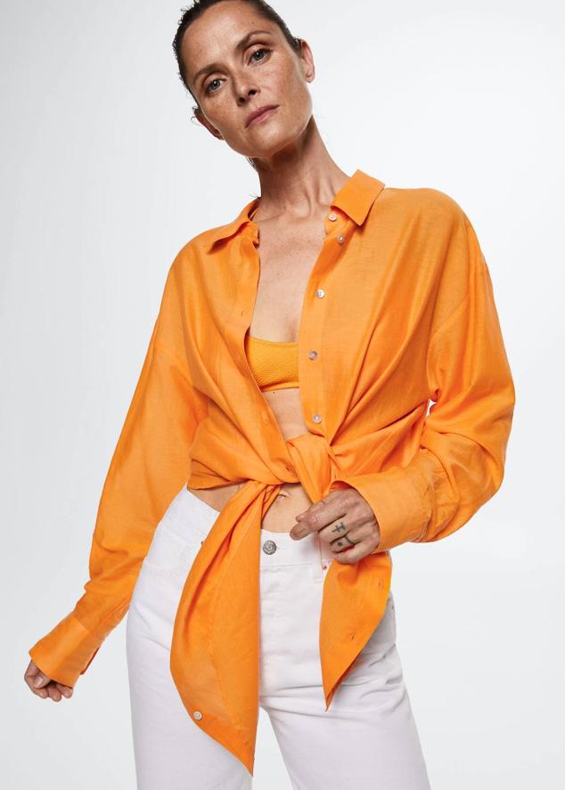 Camisa en tejido de algodón con corte oversize, manga larga, cuello solapa y cierre de botones, color naranja, de Mango. Te costará 12,99 euros, en rebajas.