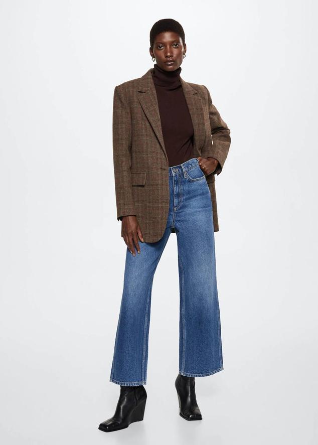 Americana de traje con cuello solapa con muesca, manga larga y bolsillos, en estampado de cuadros marrón, de Mango. Está rebajada a 49,99 euros.