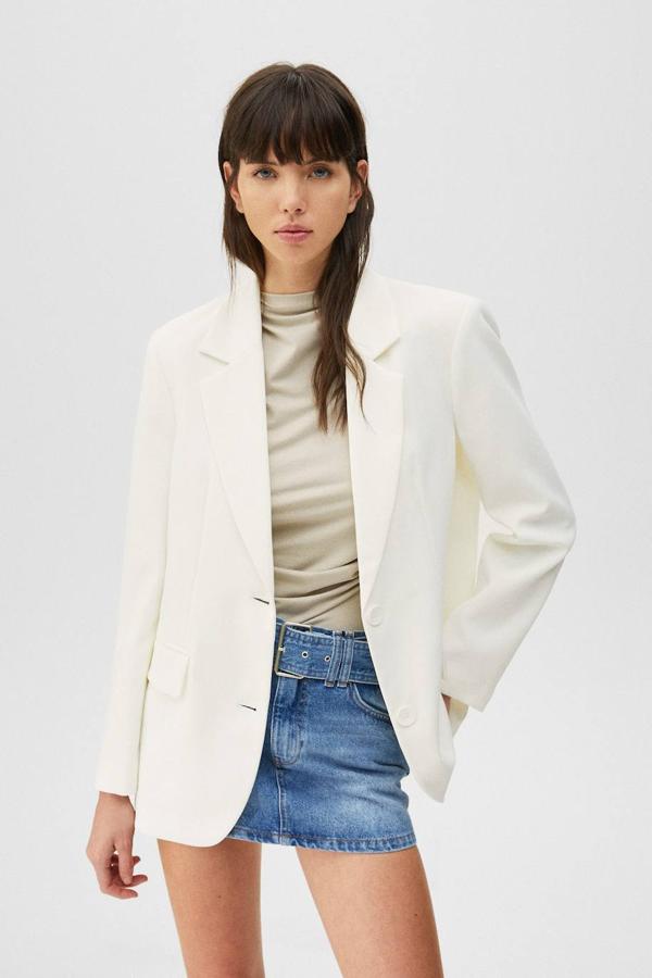 Blazer masculina con cuello solapa con muesca, manga larga, bolsillos y cierre de botones a tonos, color blanco, de Pull&Bear. Puedes comprarla con descuento por 19,99 euros.