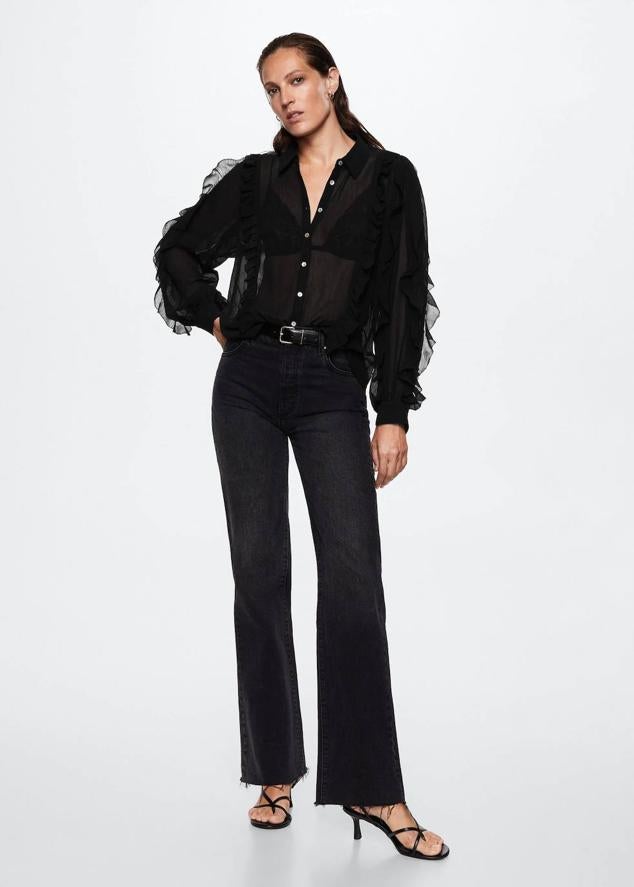 Blusa en tejido texturizado con cuello solapa, manga larga y adorno de volantes, color negro, de Mango. Su precio en rebajas es de 29,99 euros.