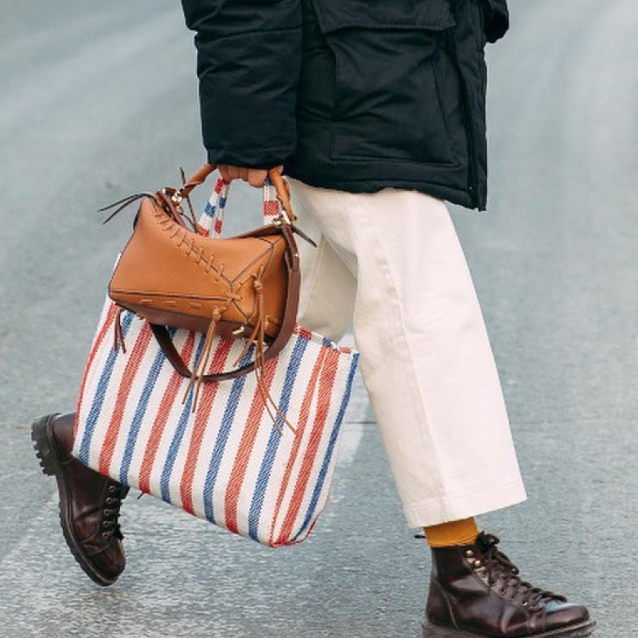 Un mujer con dos bolsos en el street style.
