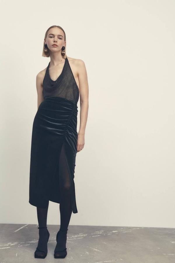 Falda midi de tubo en tejido de terciopelo con detalles drapeados y abertura en el bajo, color negro. Consíguela de rebajas por 17,99 euros.