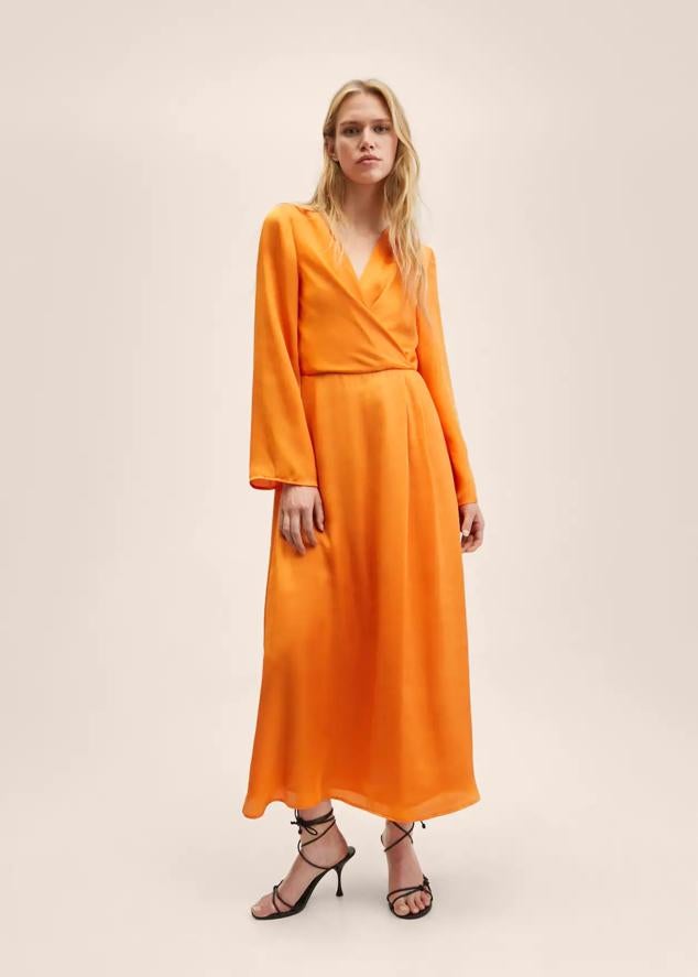 Es un vestido largo con efecto satinado y en color naranja. Cuenta con manga larga y escote en pico cruzado. Es un vestido ideal para invitadas. Precio: 34,99 euros.