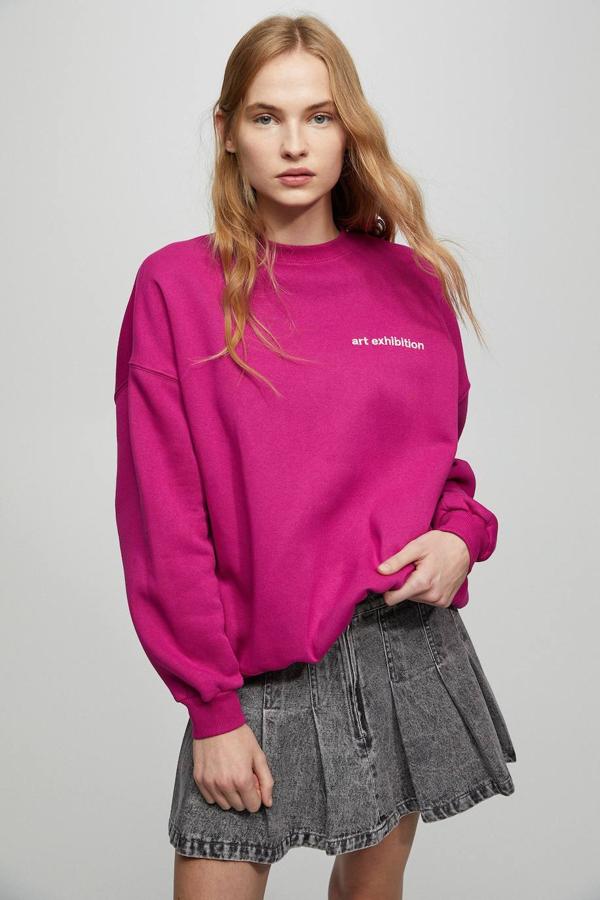 Sudadera con corte relajado, manga larga, cuello redondo y bordado, en fucsia, de Pull&Bear. Hazte con ella por 22,99 euros.
