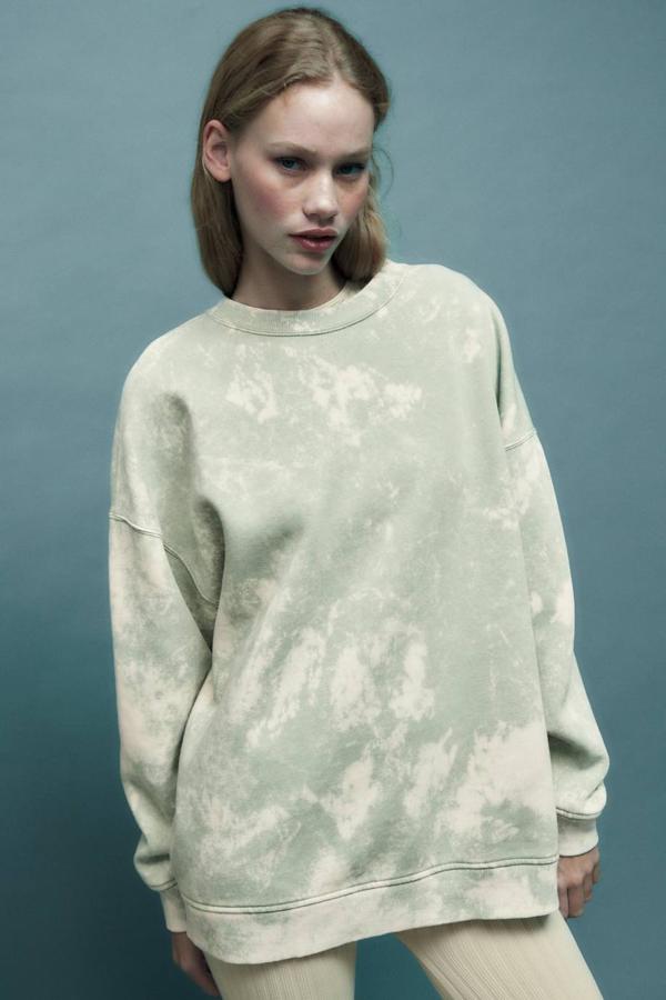 Sudadera oversize con cuello redondo, manga larga y estampado efecto lavado desgastado, tono verde claro, de Zara. Consíguela a 29,95 euros.