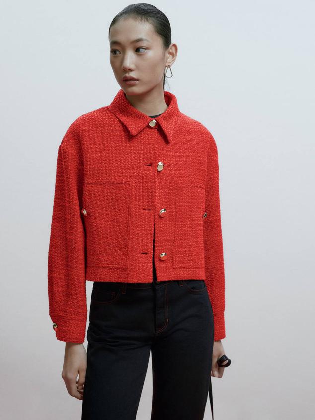 Chaqueta en tejido de tweed con diseño cuadrado, manga larga, cuello solapa, bolsillos y botones metálicos, de Massimo Dutti. Te costará 129 euros.