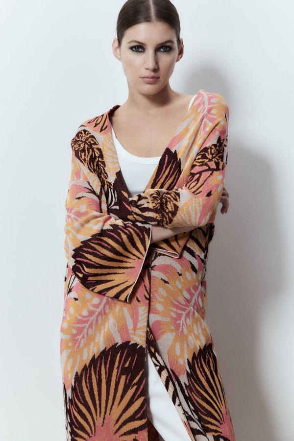 Chaqueta larga en tejido de punto jacquard con diseño abierto, mangas tipo kimono y estampado botánico coral, de Sfera. Está disponible por 35,99 euros.