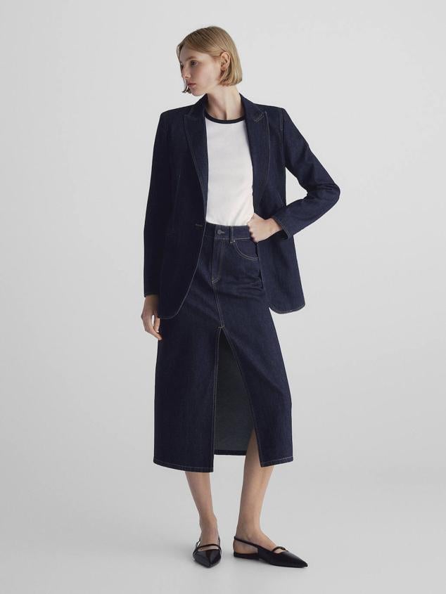 Conjunto en tejido denim con blazer recta y falda midi con abertura delantera, en azul oscuro. Su precio es de 129 euros y 59,95 euros.