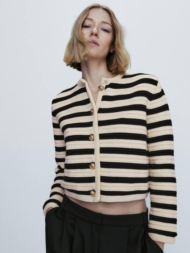Cárdigan de punto con cuello redondo, manga larga, cierre de botones dorados y estampado a rayas en crudo y negro. Cómpralo por 89,95 euros.