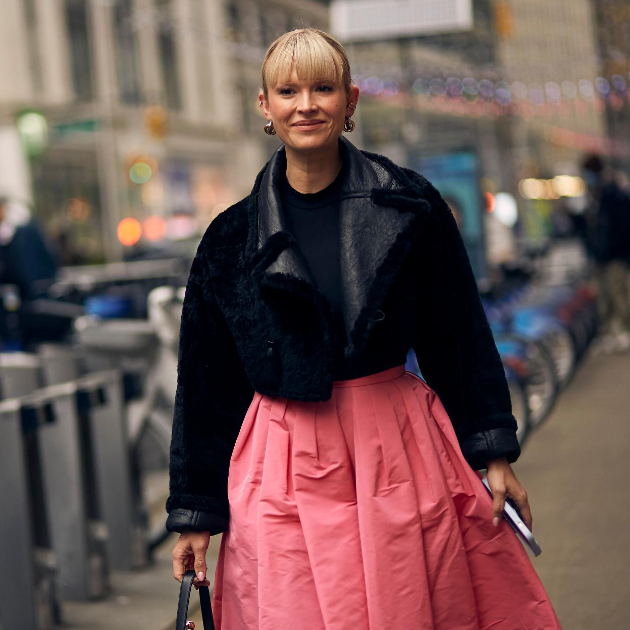 Una mujer en el street style con falda rosa.