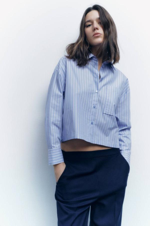 Camisa cropped con cuello solapa, manga larga, cierre de botones y detalle de bolsillos en el pecho, en azul y blanco, de Zara. Te costará 22,95 euros.
