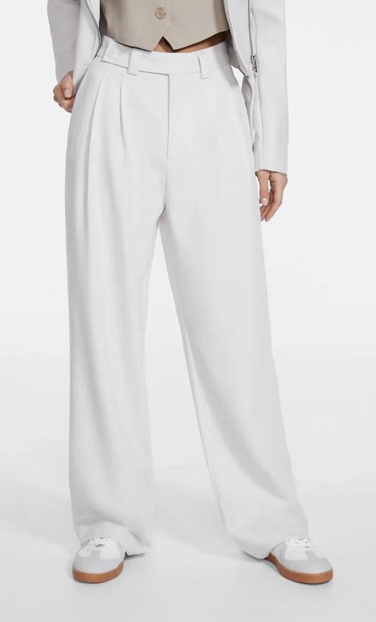 Pantalón de vestir estilo wide leg con tiro alto, pinzas y perneras rectas y anchas, color blanco, de Stradivarius. Hazte con él a 25,99 euros.