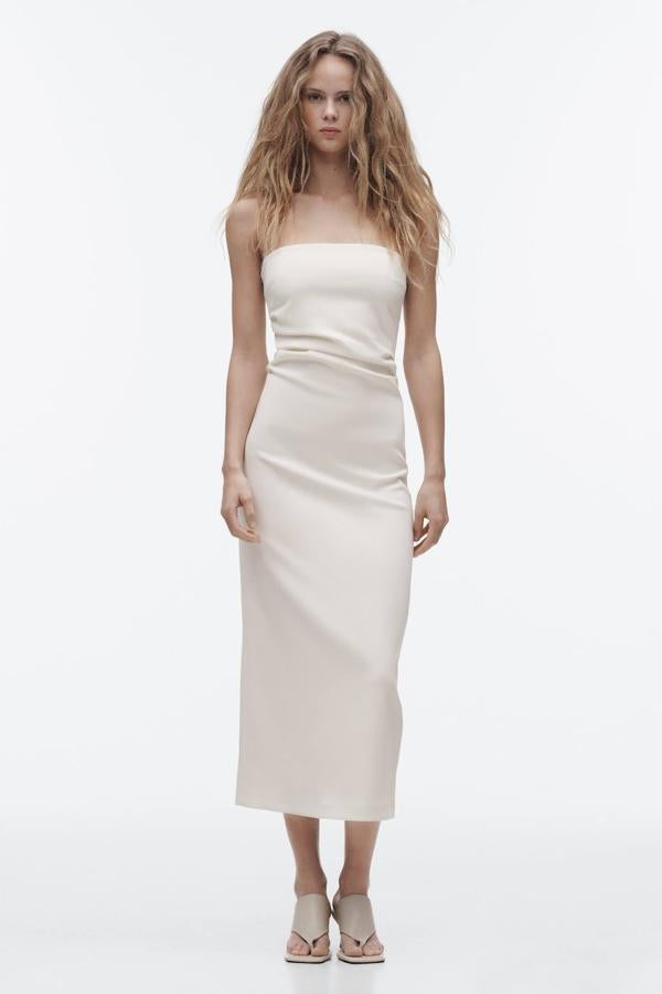 Vestido midi de tubo entallado con escote palabra de honor y abertura posterior en el bajo, en blanco, de Zara. Cuesta 35,95 euros.