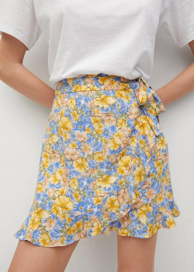 Minifalda cruzada con tejido vaporoso, terminaciones de volantes y lazada, en estampado floral amarillo y azul. Puedes encontrarla por 15,99 euros.