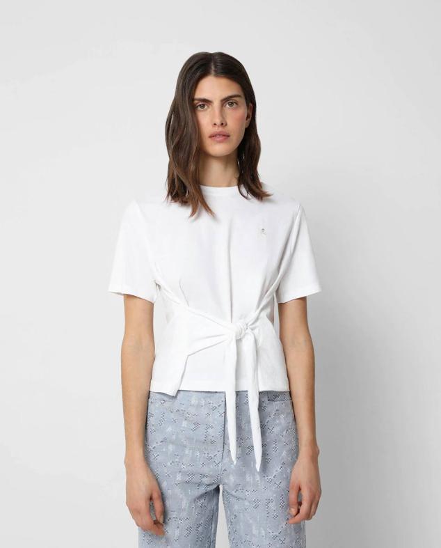 Camiseta de manga corta con cuello redondo y detalle de lazada frontal, color blanco, de Scalpers. Cuesta 29,90 euros.