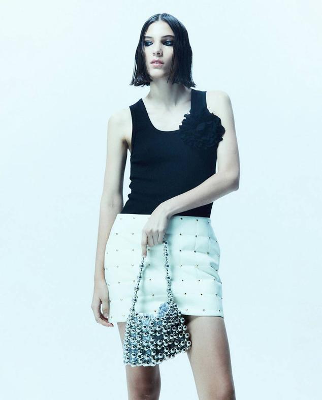 Camiseta en tejido de canalé con tirantes anchos, escote rendon y detalle de flor en relieve, en negro, de Sfera. La encontrarás a 19,99 euros.