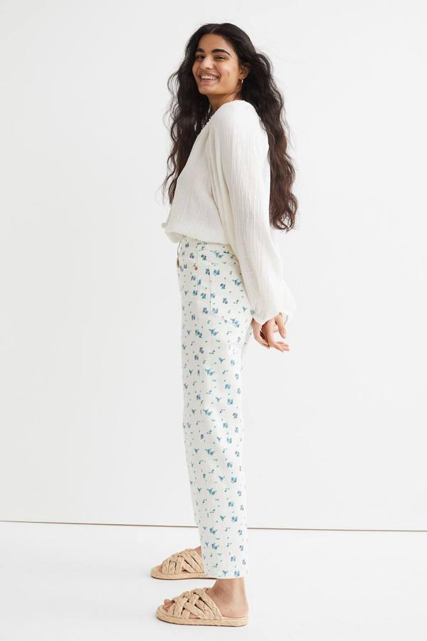 Pantalón recto con tiro alto, corte acomodado al cuerpo y estampado floral en blanco y azul, de H&M. Cómpralo por 29,99 euros.