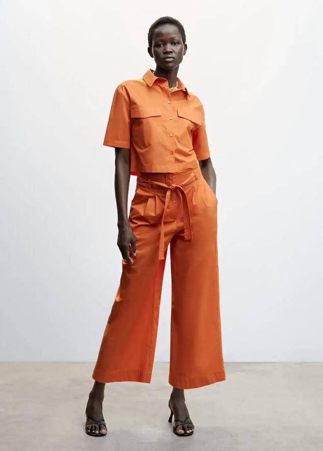 Look con camisa de manga corta y pantalón con cinturón de lazada, en naranja. Cuesta 25,99 euros y 29,99 euros.