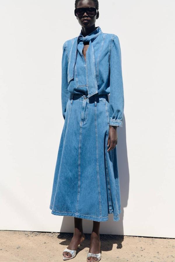 Camisa vaquera con manga larga, escote de pico y lazada al cuello, de Zara. Su precio es de 29,95 euros.