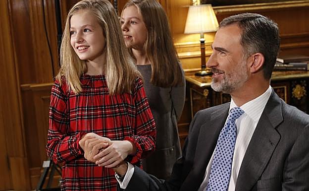 La princesa Leonor le coge la mano a su padre, durante un descanso de la grabación del tradicional mensje de Nochebuena. 
