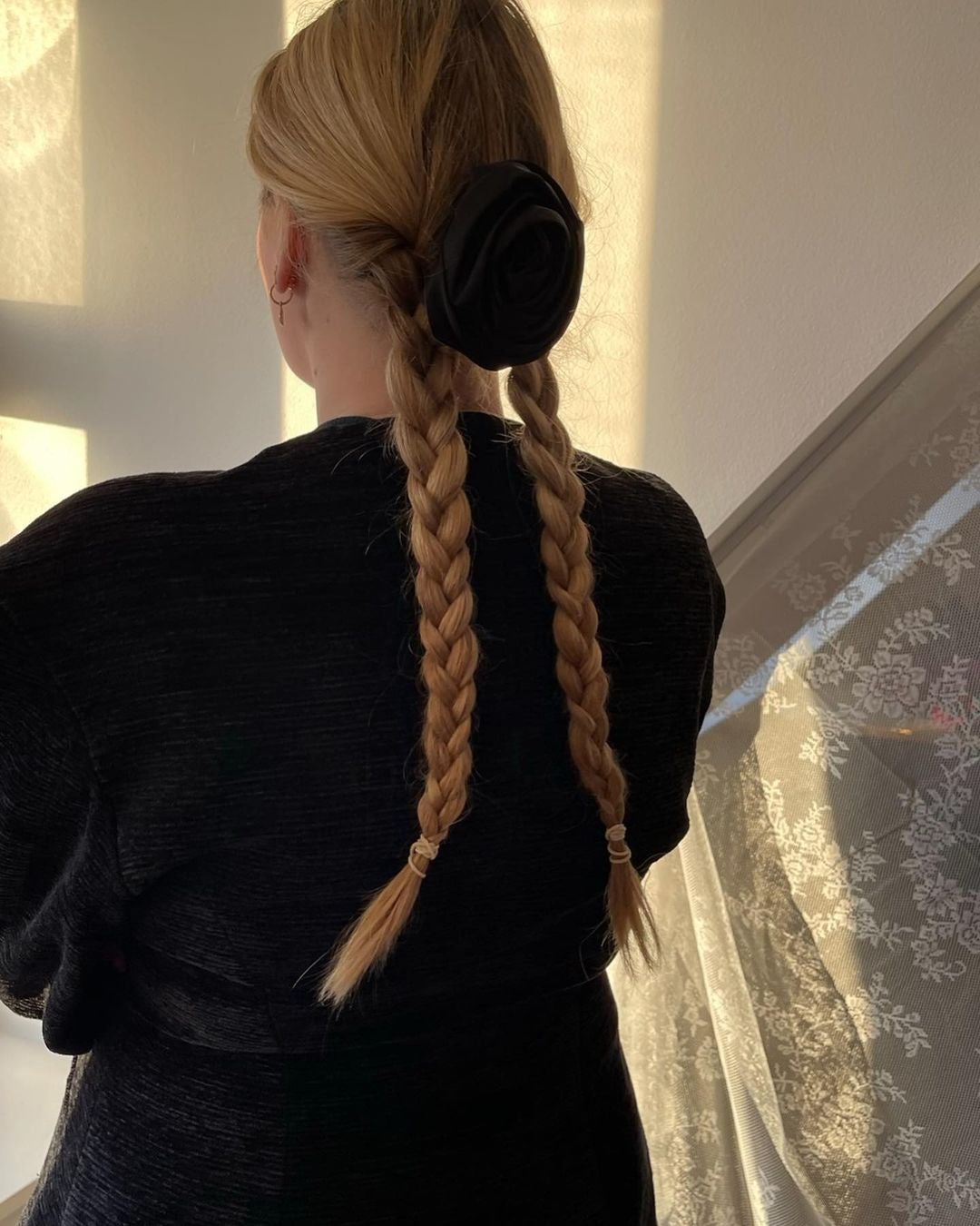 Peinado con trenzas y accesorio flor.