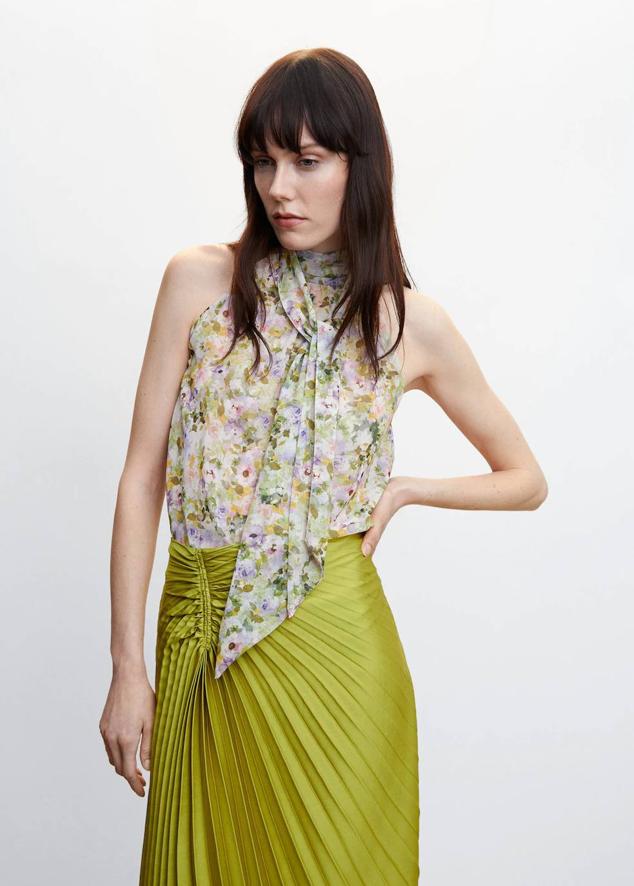 Blusa en tejido ligero sin mangas, con cuello halter y lazada, en floral print de tonos claros, de Mango. La encontrarás por 29,99 euros.