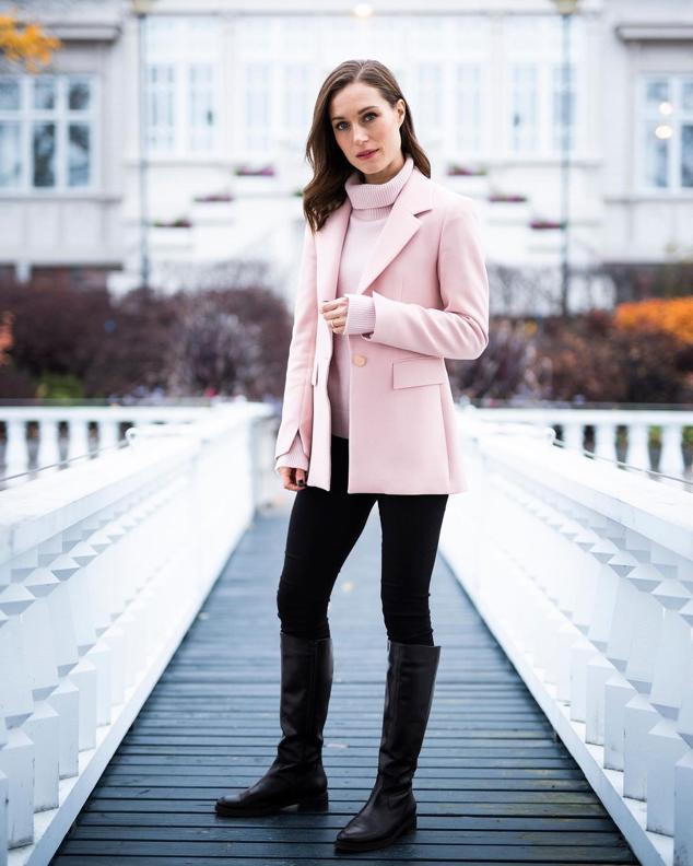 Este es uno de nuestros looks favoritos de Sanna Marin. El tip de combinar la blazer con el jersey sienta de maravilla. Un look que completó botas altas negras.
