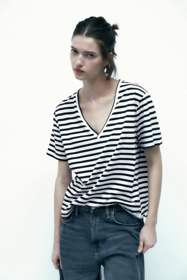 Camiseta con manga corta, escote de pico y print a rayas en blanco y negro, de Zara. Puedes comprarla por 5,95 euros.