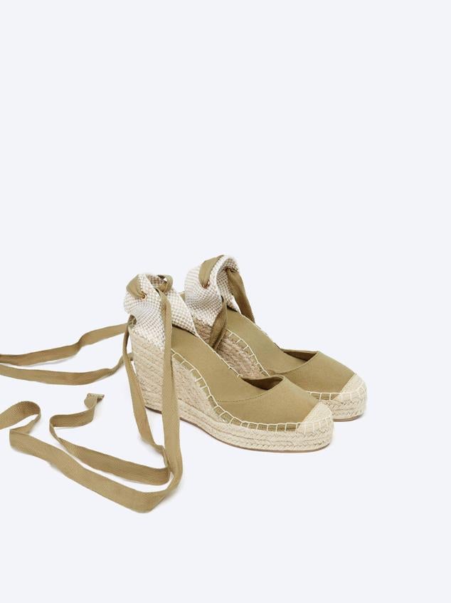 Alpargatas con cuña de yute, talonera trenzada, puntera redonda y tiras para anudar al tobillo, color khaki, de Lefties. Cuestan 25,99 euros.