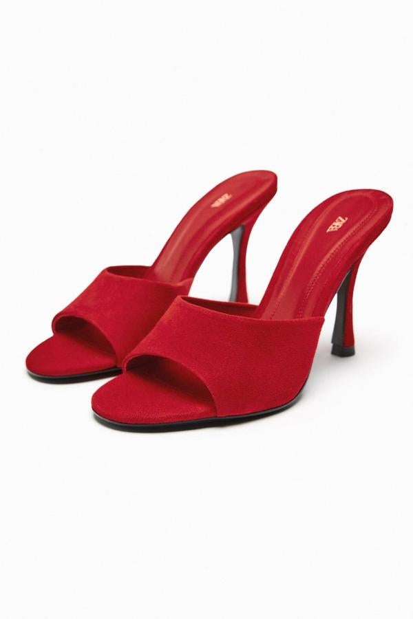 Mules de tacón alto con diseño destalonado y tira delantera, en tejido de ante color rojo, de Zara. Te costarán 69,95 euros.