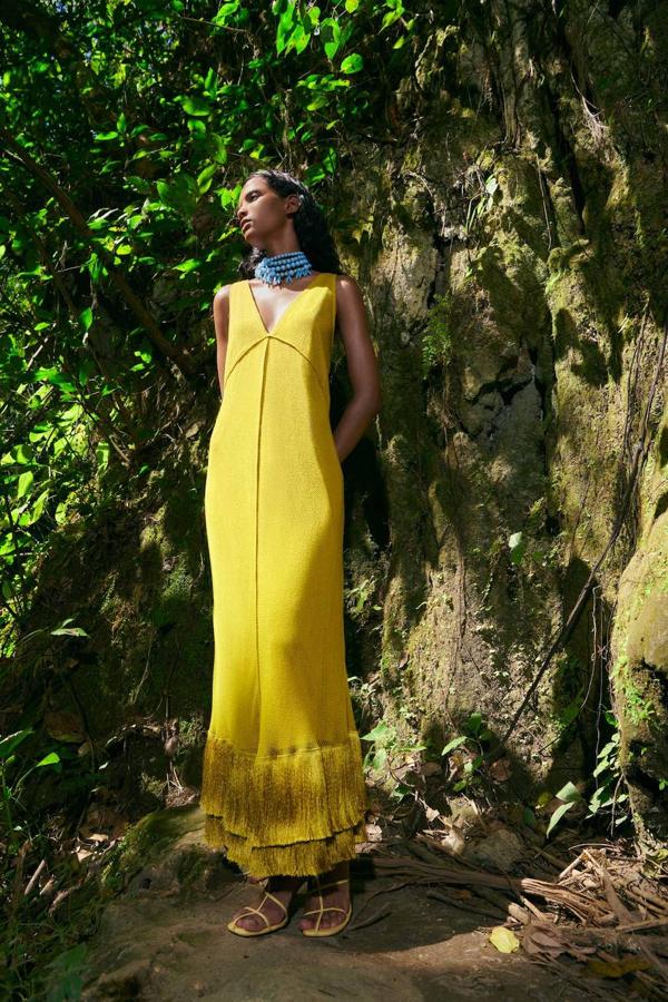 Vestido largo en tejido de red con escote de pico, tirantes anchos y bajo acabado en flecos a tono, color amarillo, de Sfera. Te costará 39,99 euros.