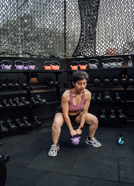 Imagen - Mujer haciendo sentadillas con pesa rusa/PEXELS