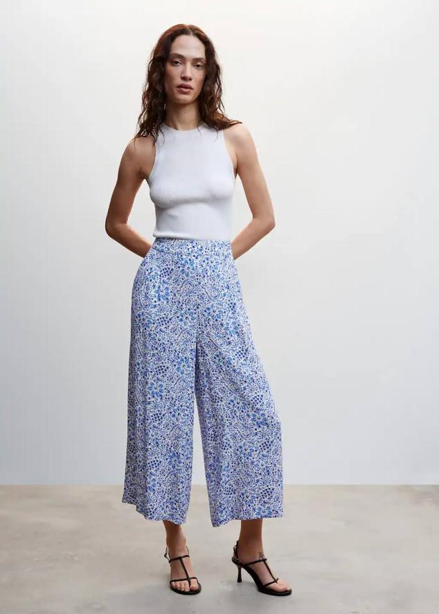 Pantalón culotte en tejido fluido con perneras anchas y cropped, tiro alto alto y cintura elástica, en estampado de flores azul. Su precio es de 22,99 euros.