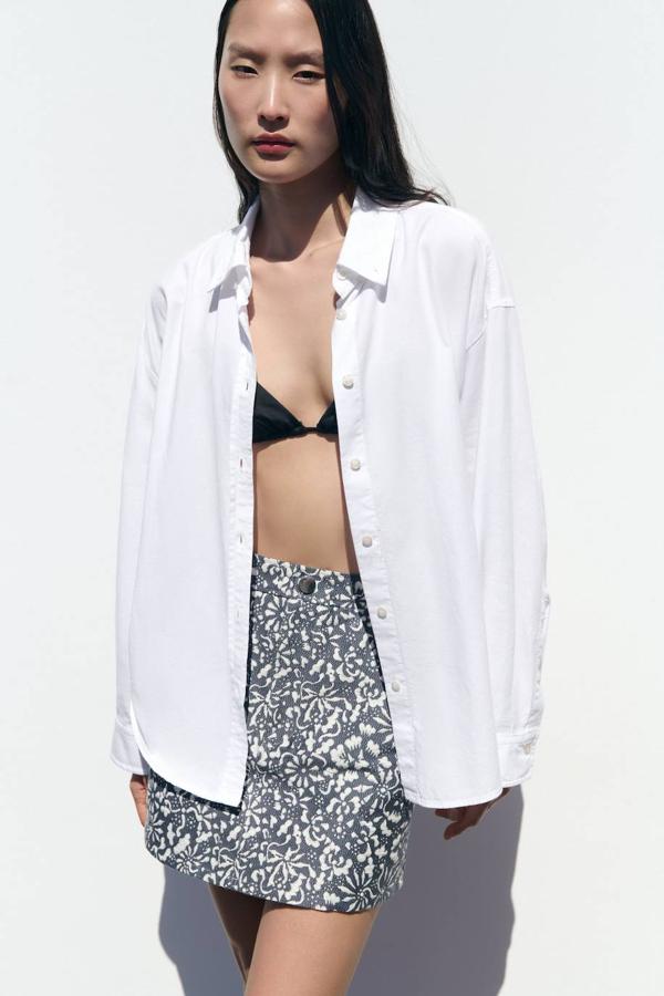 Minifalda en tejido jacquard con motivos florales, con tiro alto y bolsillos, en crudo y azul. La comprarás a 25,95 euros.