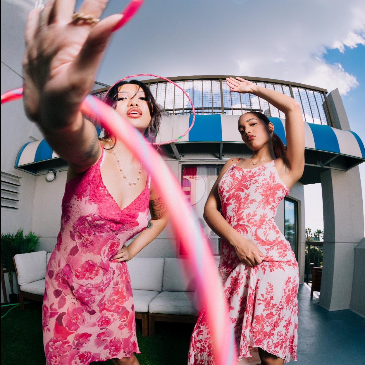Dos mujeres posando para la cámara con hula hoop. 