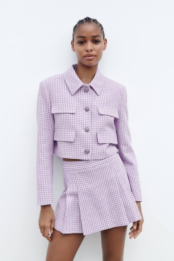 Traje de tweed con chaqueta y falda pantalón a tablas en estampado de vichy lila, de Zara. El precio de las prendas es de 49,95 euros y 25,95 euros, respectivamente.