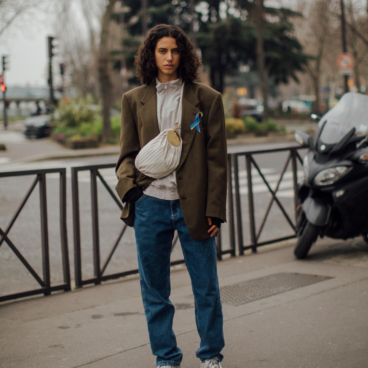 Una mujer en el street style con zapatillas deportivas y vaqueros.