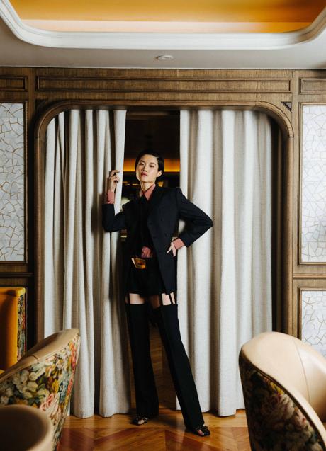 Imagen - Modelo posa con traje de aberturas inesperadas en tonos profundos.