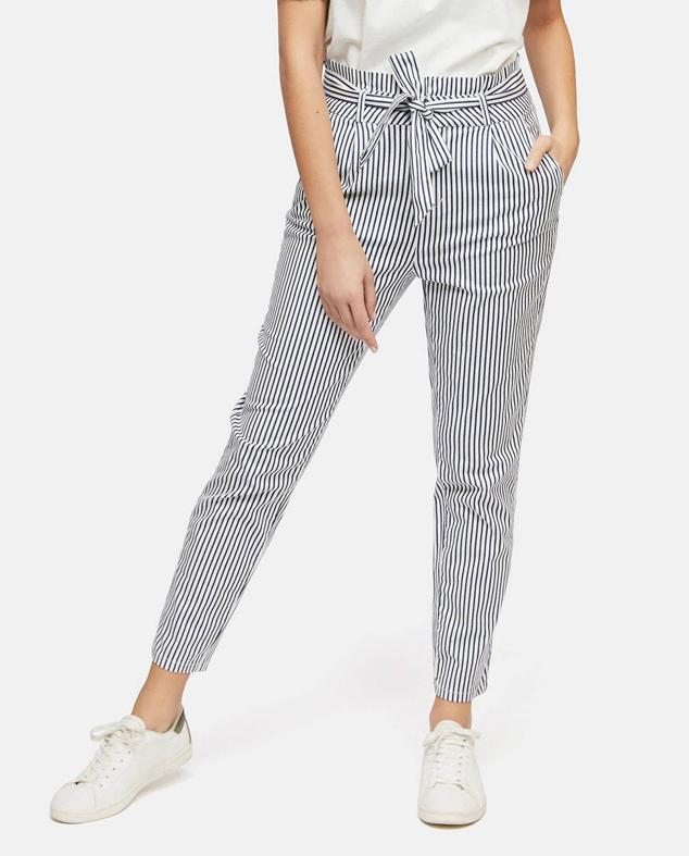 Pantalón estilo paperbag con tiro alto, cinturón de lazada, bolsillos y perneras acomodadas al cuerpo, en print a rayas azul y blanco, de Vero Moda. Te costará 39,99 euros en El Corte Inglés.