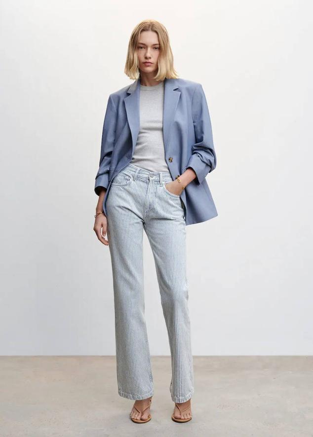 Pantalón vaquero medio con tiro medio, trabillas, bolsillos y perneras rectas, en print a rayas verticales celeste y blanco, de Mango. Hazte con él a 35,99 euros.